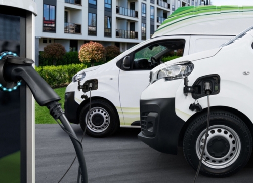 A row of electric vans charging